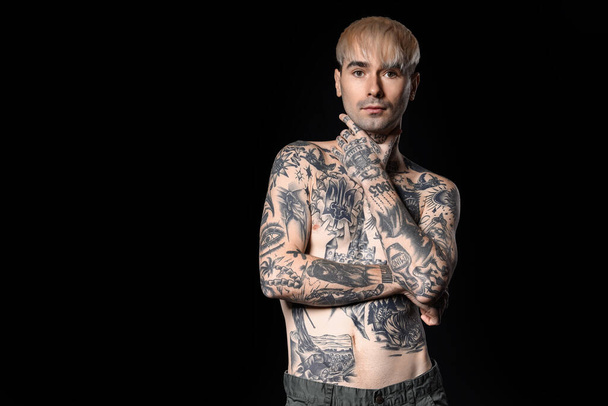 Young tattooed man on dark background - Φωτογραφία, εικόνα