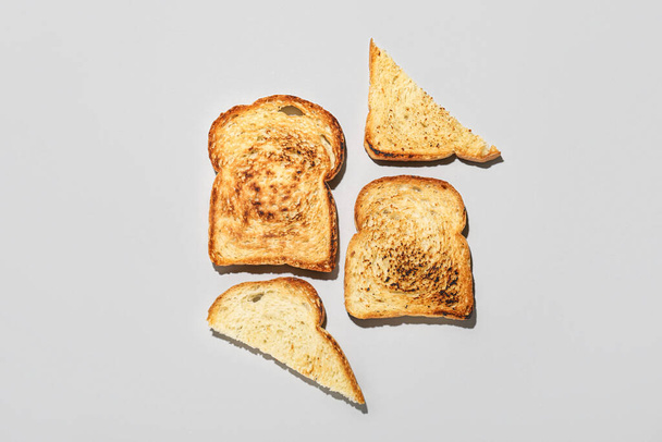 Slices of toasted bread on light background - Fotoğraf, Görsel