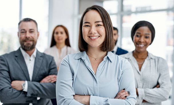 Teamwork strengthens self-growth too. Portrait of a businesswoman standing in an office with her colleagues in the background - Foto, Imagen