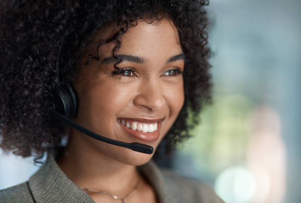 A smile is the best makeup a woman can wear. a young female agent smiling with her headset on while working in a call centre - Foto, immagini