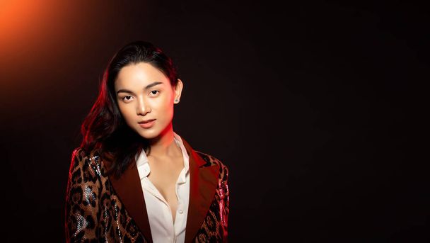 Half body portrait of Asian beautiful woman wear formal blazer, unisex handsome man look make up style. Young female express feeling smile strong over black background isolated copy space - Foto, Imagem