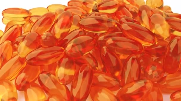 Soft gelatin capsules for containing oily drugs and nutritional supplements like vitamin A, and E. 3D rendering motion. Falling Omega-3 fish oil liquid gel capsules falling over white background - Záběry, video