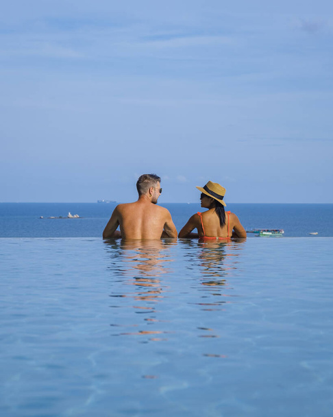 couple man and woman on a luxury vacation enjoying the infinity pool on the rooftop, Pattaya Thailand. sunny day in Pattaya - Foto, immagini