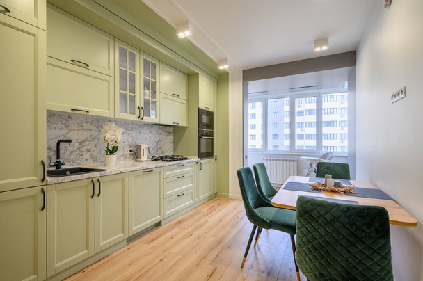 Moderna moda luz verde cozinha luxuosa com mesa de jantar e cadeiras verdes escuras - Foto, Imagem