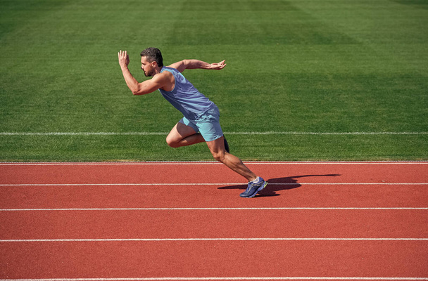 muscular athletic runner training. sport. male endurance and stamina. successful sportsman finishing. athlete runner do aerobic or anaerobic load. man start running on stadium. fitness gym outdoor. - 写真・画像