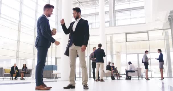 Happy business people, friends greeting with a fist bump in diverse corporate office. Businessmen greeting before working at the workplace. Young male colleagues at a fun conference networking - Felvétel, videó