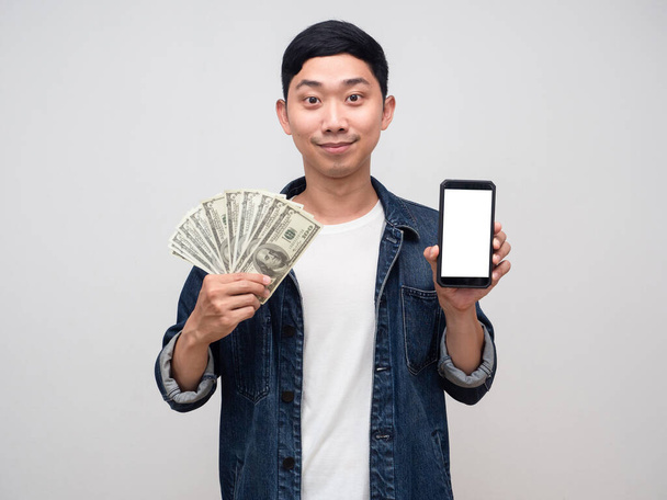 Positive man jeans shirt hold money and mobile phone isolated - Foto, afbeelding