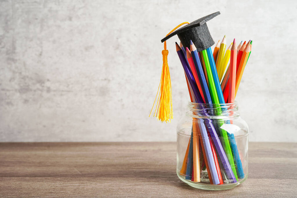 Graduation hat with colorful pencils on book with copy space, learning university education concept. - Photo, Image