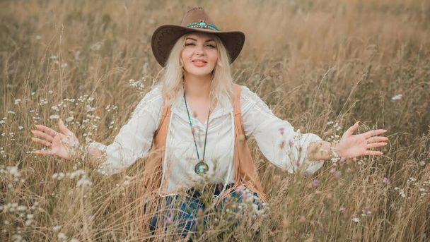 Woman Plus size in American country style black boho jacket, with a fringe, shirt and cowboy hat at nature - Foto, Imagen