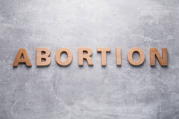 Word Abortion made of wooden letters on grey background, flat lay - Fotografie, Obrázek