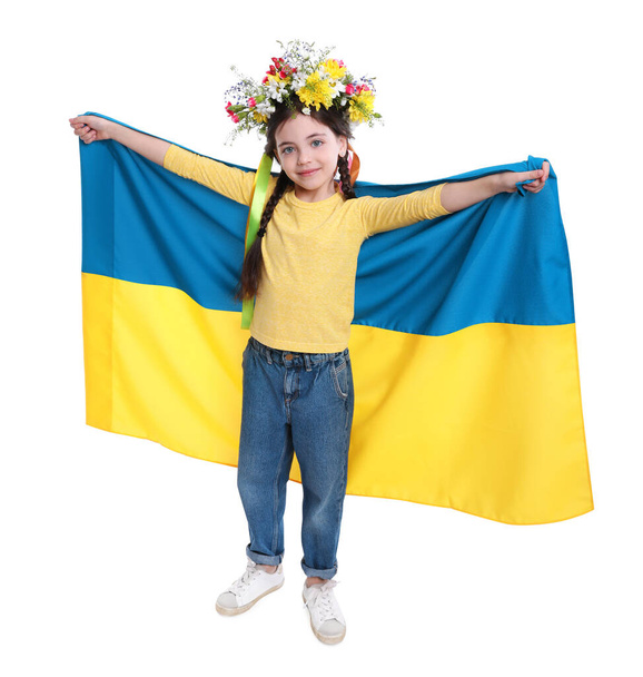 Little girl in flower wreath with flag of Ukraine on white background - Foto, Imagem