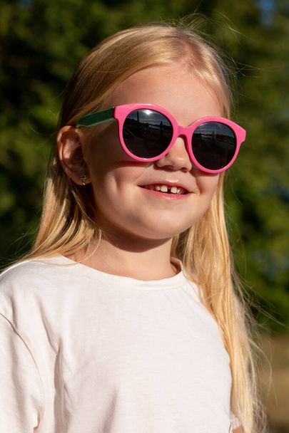 Cute  little girl with blonde hair in pink sunglasses - Photo, Image