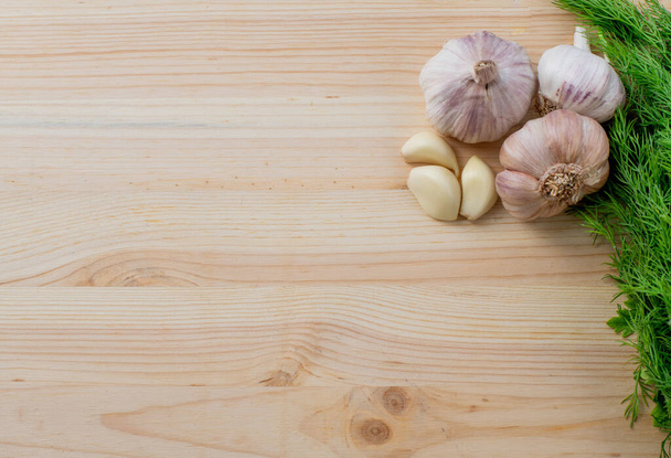 Garlic and herbs on wooden background. Top view, copy space. - Foto, imagen