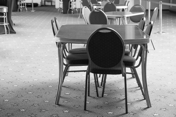 chairs and tables of a cafe in a city in black and white - Fotó, kép