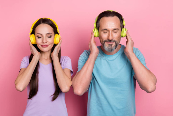Portrait of two idyllic satisfied partners closed eyes touch earphones isolated on pink color background. - Foto, Bild