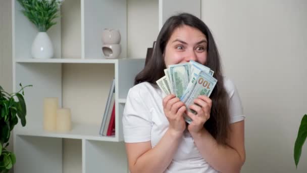 Смішна жінка тримає багато грошей і дивиться навколо з посмішкою, очікуючи покупки
 - Кадри, відео