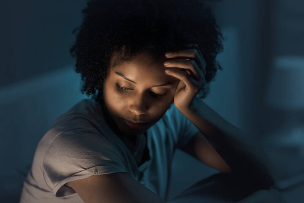 Sleepless african american woman sitting in bed at night, she is stressed and unable to sleep - Foto, Bild