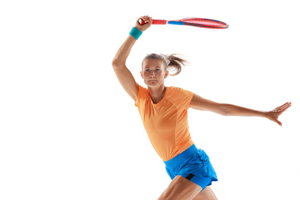Portrait of young sportive woman, professional tennis player training isolated on white studio background. Concentration. Concept of sport, health, action, motion, hobby, lifestyle. Copy space for ad - Photo, image