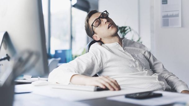 Inefficient businessman sleeping in his office, he is stressed and exhausted - Фото, зображення