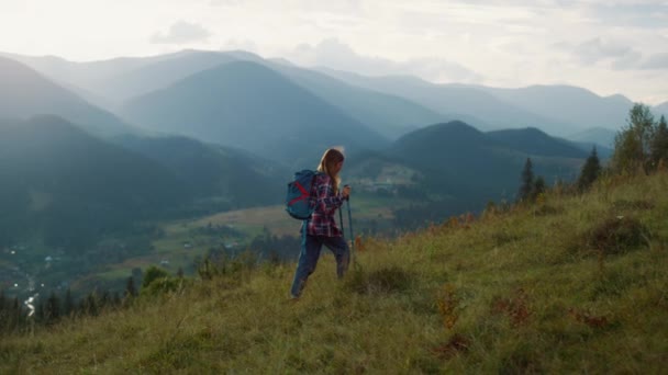 Woman climb hike mountains. Active backpacker walk nature green hill at sunrise. Alone girl enjoy weekend leisure on summer vacation. Trekker travel on majestic scene landscape. Wanderlust concept. - Materiał filmowy, wideo