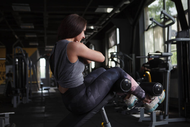 Rear view shot of a fitness woman doing sit ups at sports studio - Foto, immagini