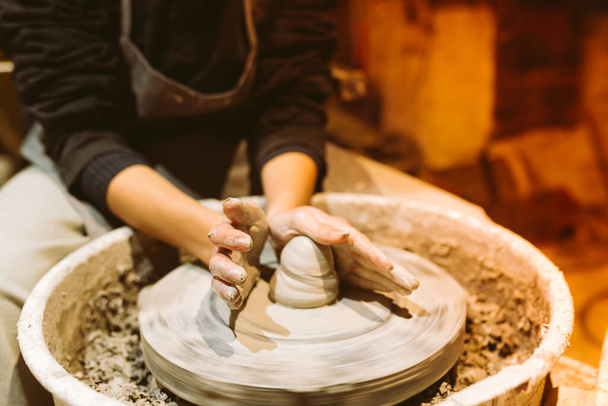 female hands of pottery master close-up work behind potter's wheel. Master class for manufacture of handcrafted ceramic products - Fotografie, Obrázek