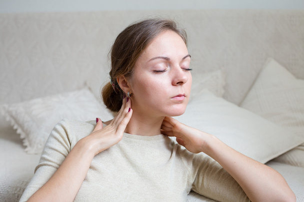 Young woman at home touching her neck in relax mood - Photo, Image