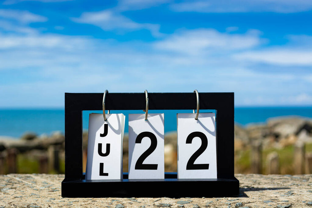 Jul 22 calendar date text on wooden frame with blurred background of ocean. Calendar date concept. - Photo, Image