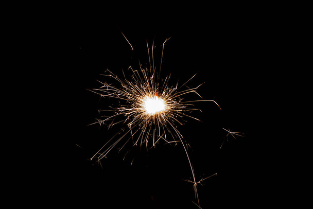 Burning sparkler isolated on black background. Fireworks theme. Light effect and texture. Christmas and new year decoration. - Foto, Bild