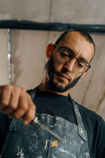 Male painter sculptor artisan works with spatula in workshop - Φωτογραφία, εικόνα
