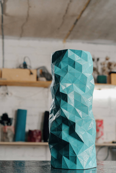 Turquoise handmade patterned vase against the backdrop of artisan workshop of the artist sculptor - Fotó, kép