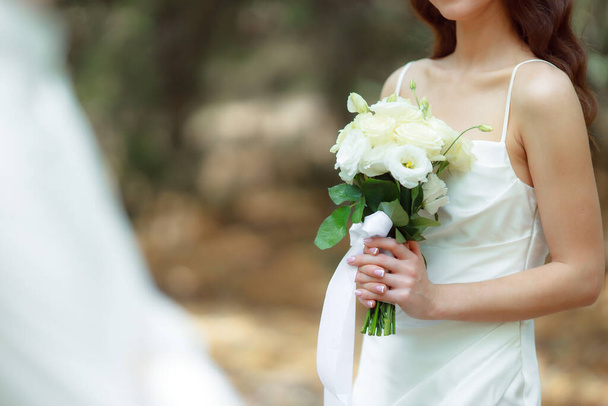 Wedding day, bride in wedding dress holding flowers bouquet - Fotografie, Obrázek