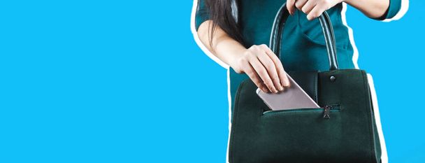 woman hand phone with bag on gray background - Fotografie, Obrázek