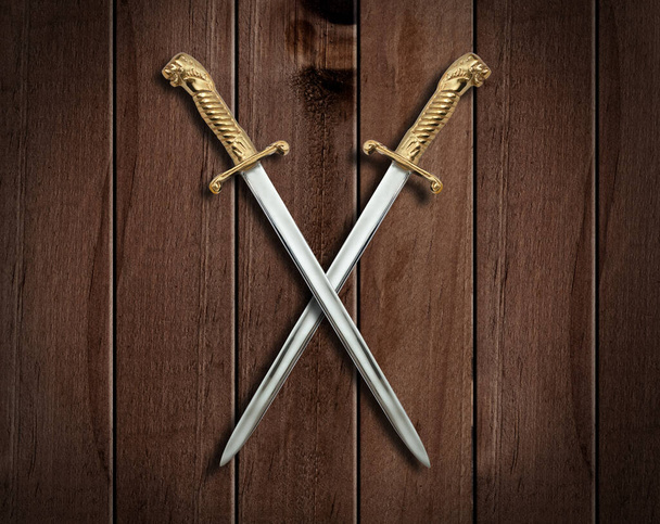 Δύο σπαθιά σε ένα παλιό ξύλινο τοίχο. - Φωτογραφία, εικόνα