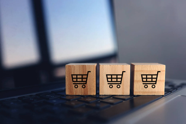 Wooden cubes with shopping cart on laptop keyboard. Online Shopping concept - Foto, imagen