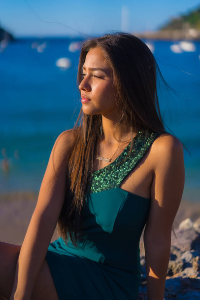 Latin young woman enjoying the summer with a green dress by the sea - Foto, Bild