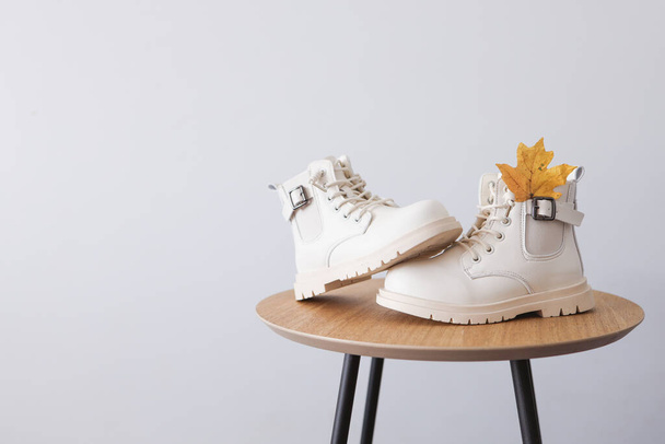 Beautiful autumn shoes with yellow leaves on a white background.Place for text - Fotó, kép