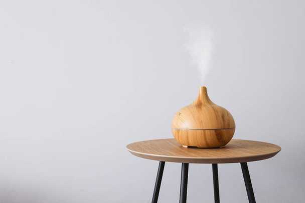 Diffuser of aromatic oil on a wooden table on a white background. - Foto, Imagen
