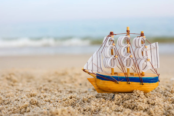 Toy ship on the sand by the sea. Summer vacation concept - Fotoğraf, Görsel