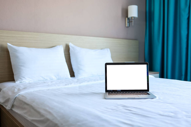 Mock up Blank screen laptop on the bed for advertising and text. - Фото, зображення