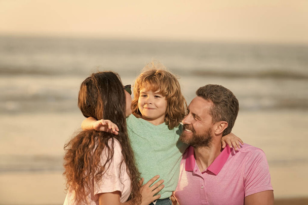 ευτυχισμένη οικογένεια της μητέρας πατέρα και του παιδιού στην παραλία του καλοκαιριού. - Φωτογραφία, εικόνα