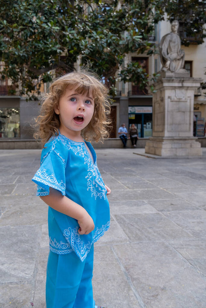 Beautiful blonde girl in arab costumes posing for camera in the streets of Granada, Spain - Photo, Image
