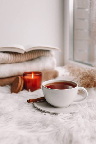 Beautiful autumn composition with burning candle and cup of tea on window sill - Foto, Bild