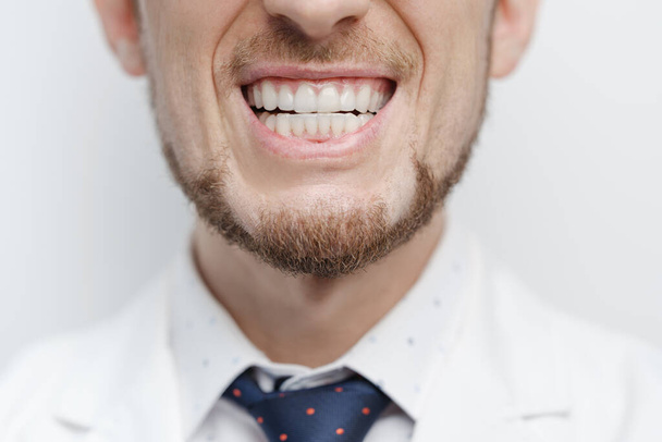 Closeup shot of male mouth with clear aligners or invisible braces on his teeth treatment - Photo, image