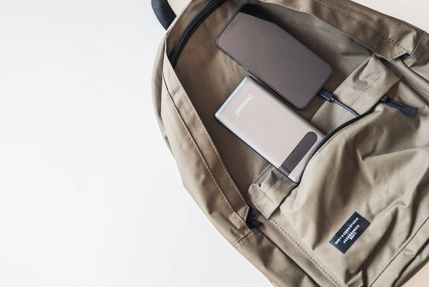 Mobile phone and power bank on a backpack. - Foto, afbeelding