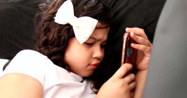 Little girl watching social media on cellphone - Materiał filmowy, wideo