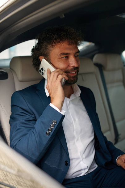 Young Businessman Calling Smartphone on Car Back Seat. Pensive man in taxi. Transport, Business Trip, Technology and People Concept  - Zdjęcie, obraz