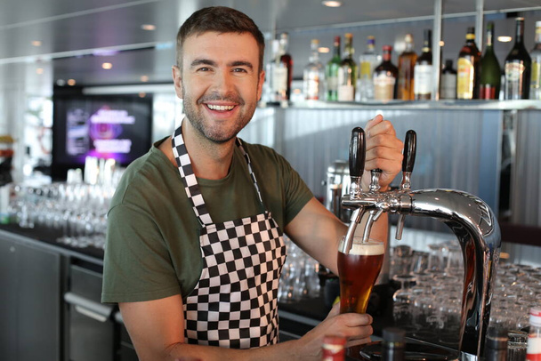close-up portrait of handsome young man working as bartender at restaurant - Zdjęcie, obraz