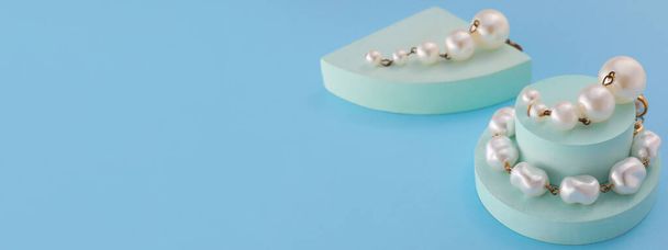 Stylish pearl earrings on light blue background with space for text - Foto, imagen