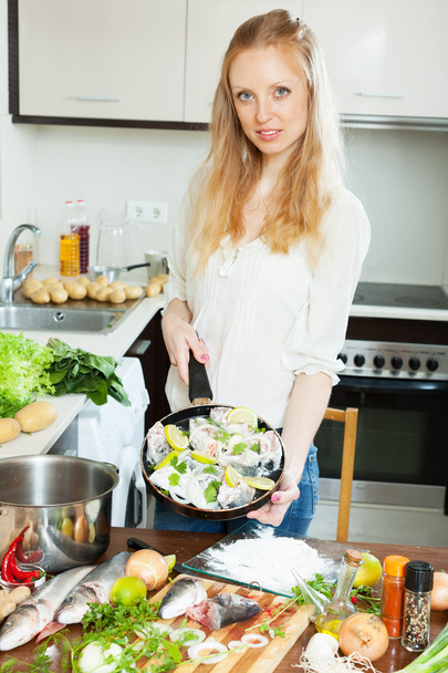 Positive woman cooking fish - Valokuva, kuva